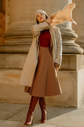 a lady in a red sweater, a brown plaid high-waist skirt and a beige coat